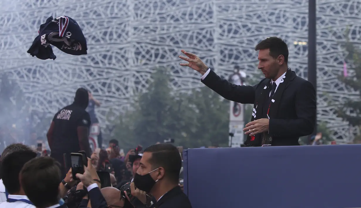 Lionel Messi melempar jersey tim ke pendukung Paris Saint-Germain (PSG) di luar stadion Parc des Princes di Paris pada Rabu (11/8/2021). Messi dikontrak oleh PSG selama dua tahun dengan opsi perpanjangan setahun di klub kaya Paris itu. (AP Photo/Rafael Yaghobzadeh)