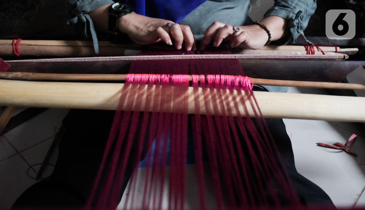 Warga mengikuti pelatihan pembuatan kain tenun motif Betawi di Rusunawa Jatinegara, Jakarta, Rabu (13/11/2019). Pemerintah akan memprioritaskan penyaluran KUR kelompok, seiring dengan diturunkannya suku bunga KUR per 1 Januari 2020 menjadi 6 persen, dari  7 persen. (Liputan6.com/Angga Yuniar)
