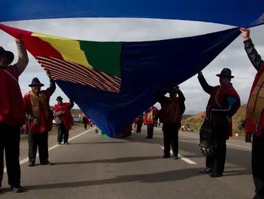 Pasukan Aymara memegang bendara angkatan laut Bolivia di jalan raya antara Oruro dan La Paz Bolivia (10/3). Sebuah bendera yang dominan berwarna biru di bentangkan sejauh 150 mil atau 200 kilometer. (AP Photo / Juan Karita)