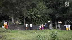 Warga mengamati aliran lahar dingin saat akan beribadah di sekitar Sungai Yeh Sah, Karangasem, Bali, Jumat (1/12). Warga berharap diberi keselamatan dan berkah dari erupsi Gunung Agung yang terjadi. (Liputan6.com/Immanuel Antonius)