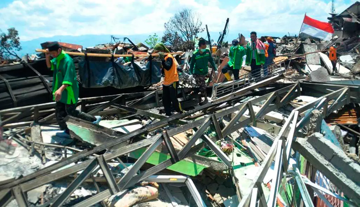 Tim penyelamat membawa tubuh korban setelah gempa dan tsunami menghantam Palu, Sulawesi Tengah, Senin (1/10). Sebanyak 18 negara menawarkan bantuan untuk bencana gempa dan tsunami Palu-Donggala. (AP Photo/Rifki)