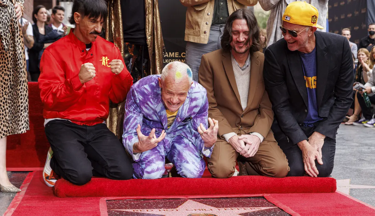 Personel Red Hot Chili Peppers, Anthony Kiedis, Flea, John Frusciante dan Chad Smith berpose saat merayakan dalam upacara peresmian band tersebut yang mendapatkan bintang di Hollywood Walk of Fame, Los Angeles, California, Kamis (31/3/2022). (Willy Sanjuan/Invision/AP)