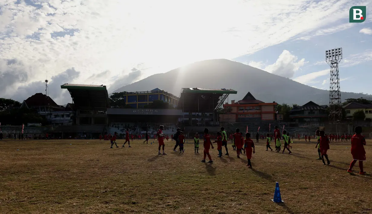 <p>Suasana&nbsp;saat kegiatan&nbsp;coaching clinic di Stadion Gelora Kie Raha, Ternate, dengan latar gunung Gamalama, Minggu (13/8/2023) sore hari WIT. (Bola.com/Okie Prabhowo)</p>