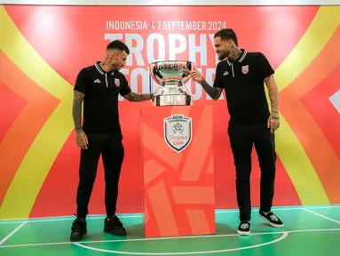 Pemain Borneo FC, Stefano Lilipaly (kiri) dan Diego Michiels mengamati trofi dalam acara Trophy Tour ASEAN Club Championship Shopee Cup 2024 di LOTTE Shopping Avenue, Event Atrium, Jakarta Selatan pada Sabtu (07/09/2024). (Bola.com/Bagaskara Lazuardi)