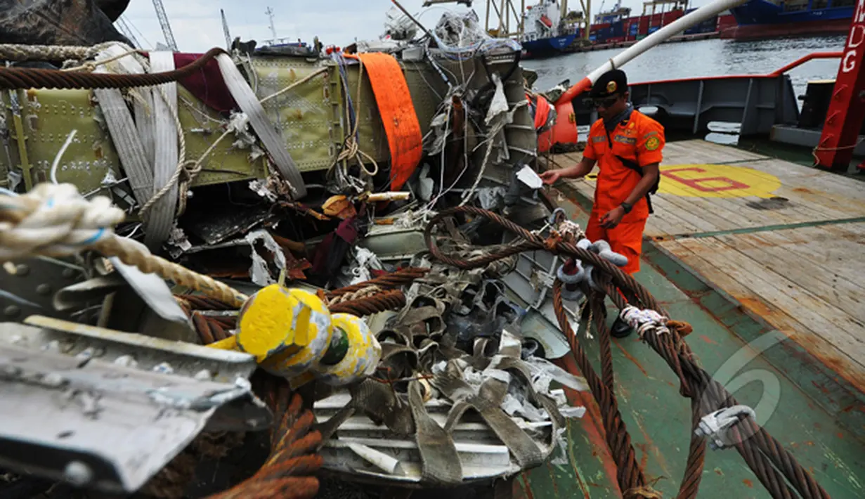 Petugas dari Basarnas memperlihatkan puing dari bangkai badan pesawat Airasia QZ8501 di Pelabuhan Tanjung Priok, Jakarta, Senin (2/3/2015). (Liputan6.com/Faizal Fanani)