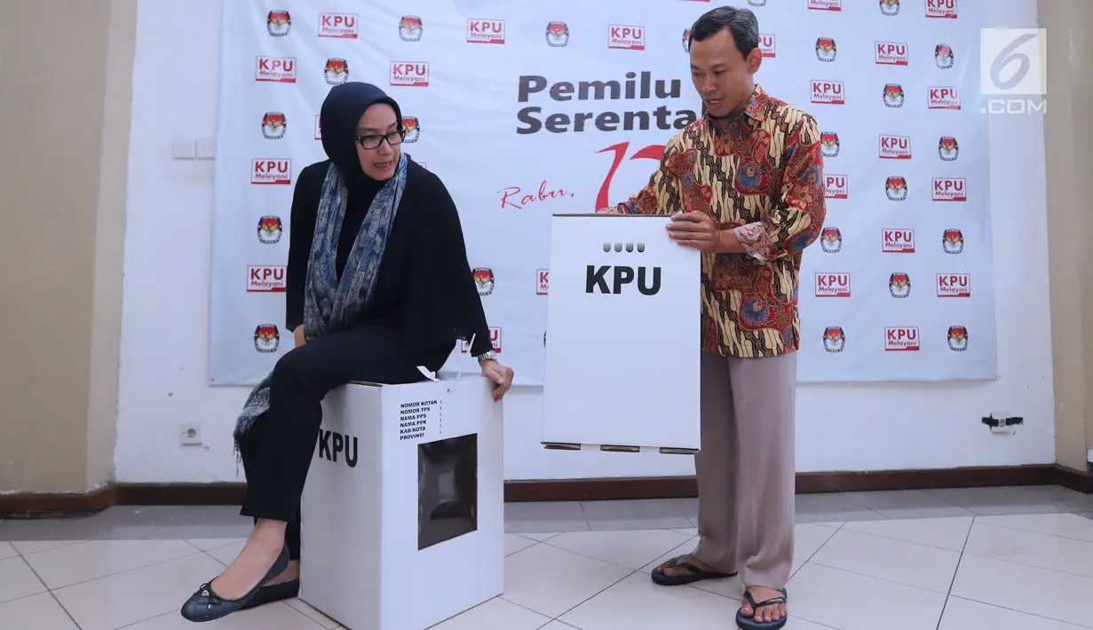 Komisioner KPU RI, Evi Novida GM (kiri) dan Pramono UT mencoba kekuatan kotak suara yang akan digunakan pada Pemilu Serentak 2019 di Kantor KPU, Jakarta, Jumat (14/12). Kotak suara tersebut bermaterial karton kedap air. (Liputan6.com/Helmi Fithriansyah)