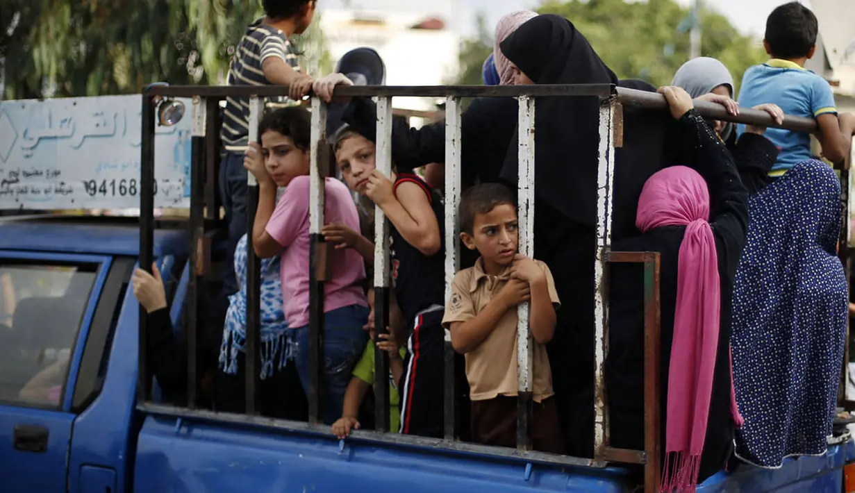 Beberapa bocah diangkut dengan kendaraan terbuka saat harus meninggalkan Shujayeh, (20/7/2014), menyusul kian meningkatnya serangan militer Israel ke Gaza, Palestina. (REUTERS/Mohammed Salem)