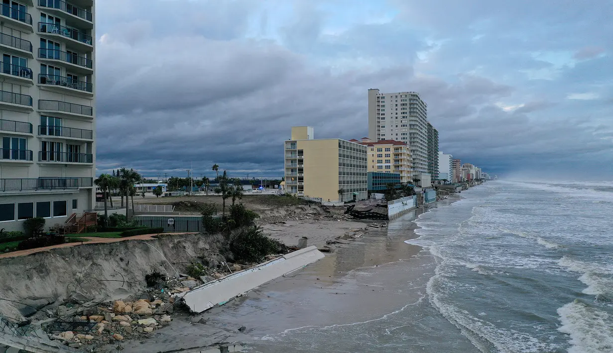 Dalam tampilan udara ini, tembok laut di sepanjang bangunan kondominium terlihat terhantam Badai Nicole di Pantai Daytona, Florida (10/11/2022). Badai Nicoler datang ke darat sebagai badai Kategori 1 sebelum melemah menjadi badai tropis saat bergerak melintasi negara bagian. (Joe Raedle/Getty Images/AFP)
