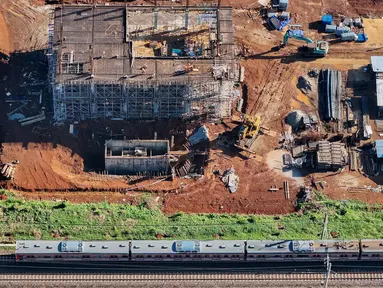Rangkaian keret rel listrik (KRL) melintas di dekat proyek pembangunan Stasiun Jatake, Pagedangan, Kabupaten Tangerang, Banten, Selasa (9/7/2024). (merdeka.com/Arie Basuki)
