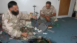 Anggota militer Libya menjinakkan bom rakitan milik militan ISIS di Sirte (5/9). Setelah berhasil menaklukkan salah satu markas ISIS, Militer Libya menemukan bom rakitan dan senjata peledak lainnya yang masih aktif. (REUTERS/Hani Amara)