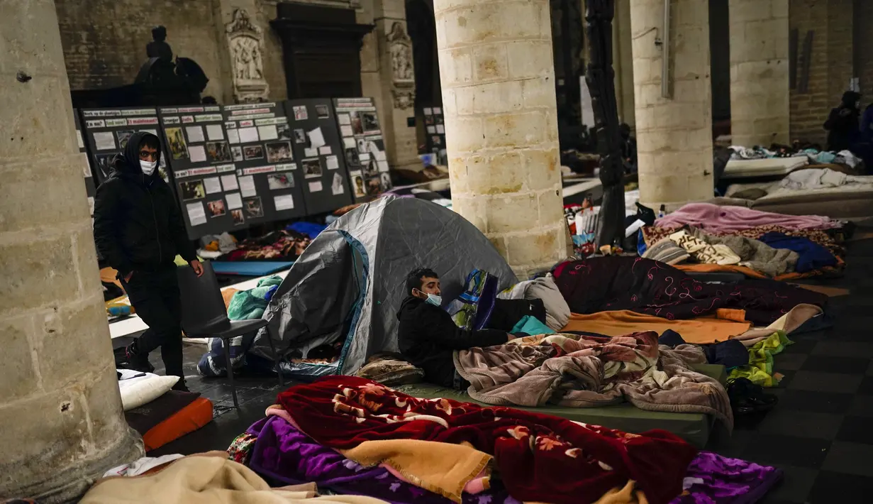 Orang-orang beristirahat di kasur saat mereka menempati gereja Saint-Jean-Baptiste-au-Beguinage di Brussels, Belgia, Selasa (2/2/2021). Beberapa ratus imigran tanpa surat-surat resmi, dengan izin pastor, telah menduduki gereja sejak Minggu, 31 Januari 2021 lalu. (AP Photo/Francisco Seco)