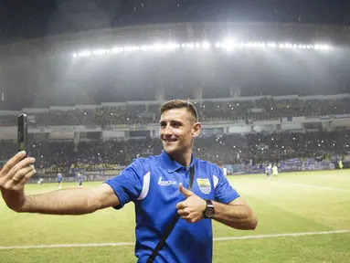 Striker anyar Persib Bandung, Juan Belencoso, tampak takjub dengan kemeriahan pendukung Maung Bandung atau Bobotoh di Stadion Wibawa Mukti, Bekasi. Dirinya aksi selfie dengan latar belakang Bobotoh. (Bola.com/Vitalis Yogi Trisna)