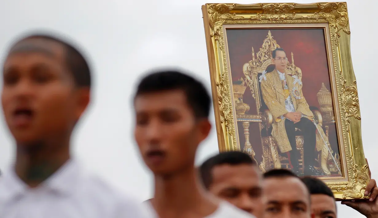 Foto Raja Thailand Bhumibol Adulyadej yang dibawa saat memberi penghormatan untuk mendiang di penjara Pathum Thani, Bangkok, Thailand (27/10). (Reuters/Chaiwat Subprasom)