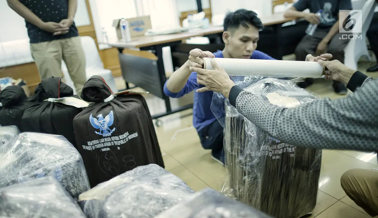 Petugas membungkus plastik paket berisi surat suara Pemilu 2019 susulan di Gedung KPU RI, Jakarta, Minggu (28/4/2019). Surat suara susulan tersebut akan dikirimkan ke Kuala Lumpur, Malaysia untuk pelaksanaan pemilihan Presiden dan Wakil Presiden. (Liputan6.com/Faizal Fanani)