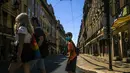Turis menyeberang jalan di pusat kota Lisbon (14/7/2021). Pemerintah berusaha untuk mengendalikan kebangkitan infeksi virus corona, karena varian Delta yang lebih menular. (AFP/Patricia De Melo Moreira)