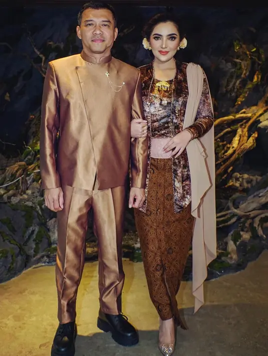 Ini adalah momen Tedak Siten cucu dari anak sambungnya, Aurel. Tampil serasi dengan sang suami, Ashanty mengenakan kebaya beludru bermotif flora yang super cantik berwarna cokelat, yang serasi dengan kain batik dan selendangnya. [Foto: Instagram/ashanty_ash]