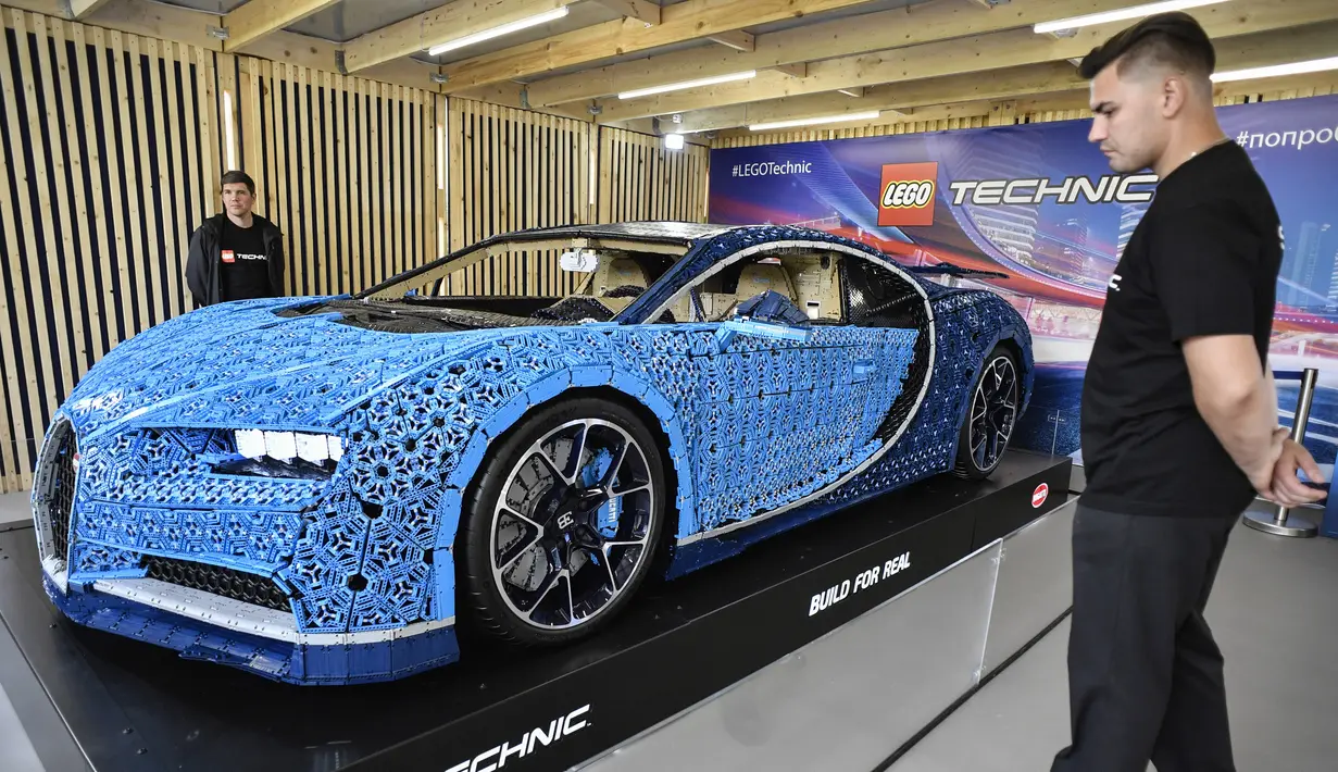 Pengunjung mengamati replika mobil Bugatti Chiron dari jutaan balok Lego Technic pada sebuah pameran di Taman Gorky Moskow, Selasa (23/7/2019). Mobil berwarna biru tersebut dibuat menggunakan lebih dari 1 juta blok Lego Technic dengan berat totalnya sekitar 1.500 kg. (Alexander NEMENOV/AFP)