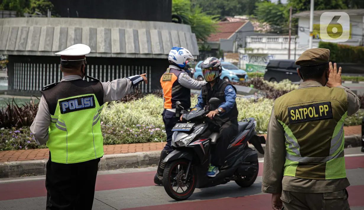 Petugas kepolisian mengawasi kendaraan yang melintasi titik pemeriksaan ganjil-genap Bundaran Senayan, Jakarta, Kamis, (26/8/2021). Mulai 26 sampai 30 Agustus, ganjil genap hanya berlaku di 3 ruas jalan Jakarta yakni, Jalan Sudirman, MH Thamrin, dan HR Rasuna Said. (Liputan6.com/Faizal Fanani)