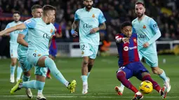 Striker Barcelona, Raphinha (kanan) melepaskan tendangan yang berusaha diblok bek Mallorca, Antonio Raillo (kiri) pada laga pekan ke-28 LaLiga 2023/2024 yang berlangsung di Olimpic Lluis Companys Stadium, Barcelona, Sabtu (9/3/2024) dini hari WIB. (AP Photo/Joan Monfort)