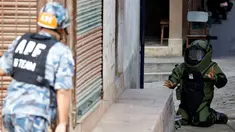 Anggota kepolisian mengenakan pakaian khusus saat menjinakkan bom yang ditemukan di sekitar sekolah di Kathmandu, Nepal, Selasa (20/9). Otoritas berwenang setempat mengabarkan ada 5 sekolah yang ditemukan bom di kota tersebut. (REUTERS/Navesh Chitrakar)