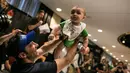 Seorang ayah mengangkat anaknya setelah mengikuti lomba merangkak dalam Diaper Derby NYC triathlon di New York City (14/7). (AFP Photo/Dominick Reuter)
