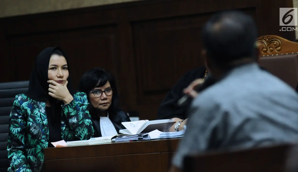 Bupati nonaktif Kutai Kartanegara, Rita Widyasari (kiri) menyimak keterangan saksi pada sidang lanjutan dugaan suap pemberian izin lokasi perkebunan kelapa sawit di Pengadilan Tipikor, Jakarta, Rabu (14/3).(Liputan6.com/Helmi Fithriansyah)