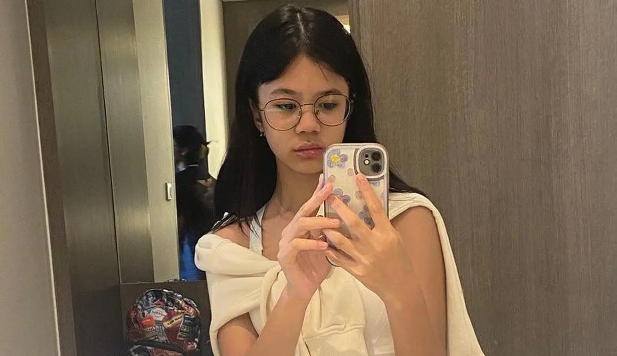 Tampil kekinian, kombinasi tank top dengan cardigan yang diikat sebagai luaran dan celana jeans bikin look makin stylish. [@shafeeamd_/@elelrumi].