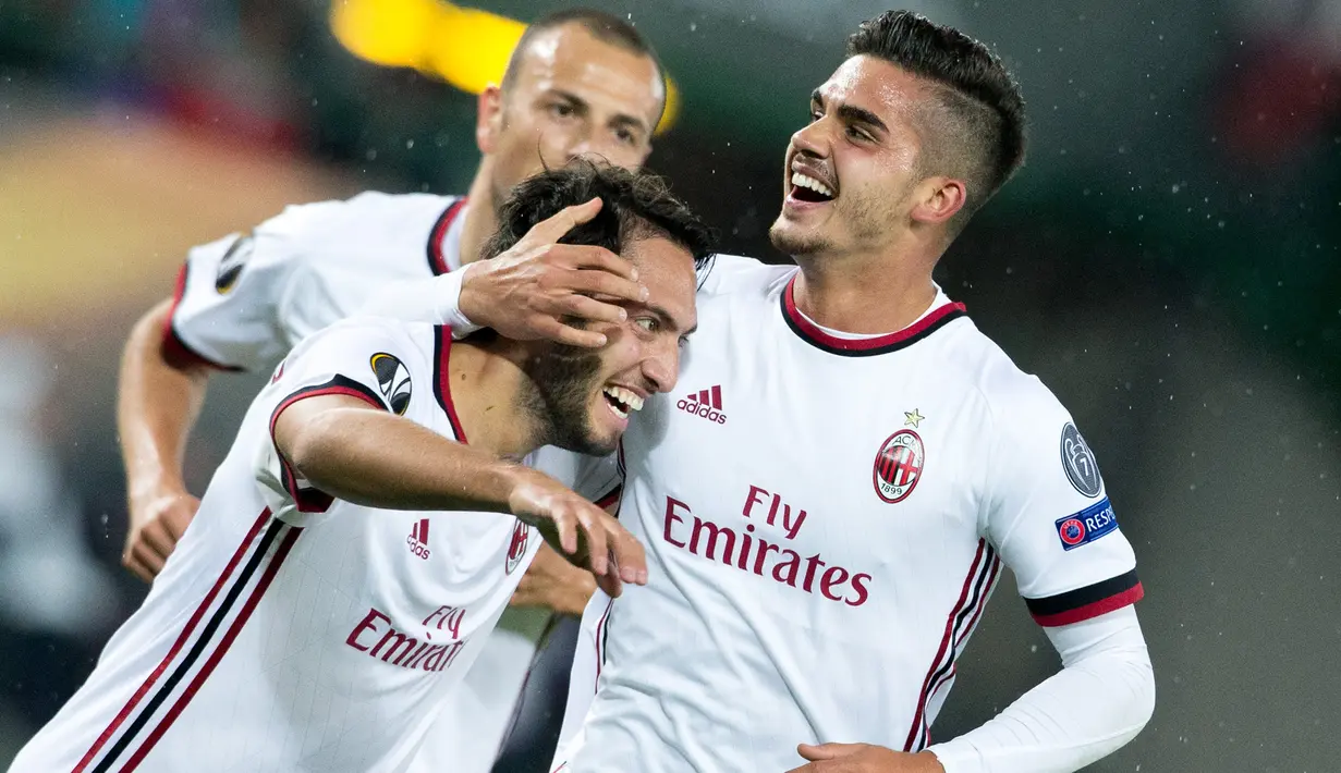 Penyerang AC Milan, Andre Silva (kanan) melakukan selebrasi dengan Hakan Calhanoglu usai mencetak gol ke gawang Austria Wien pada Grup D Liga Europa di Ernst Happel Stadium, (14/9). Silva mencetak hattrick di pertandingan ini. (Georg Hochmuth/Apa/AFP)