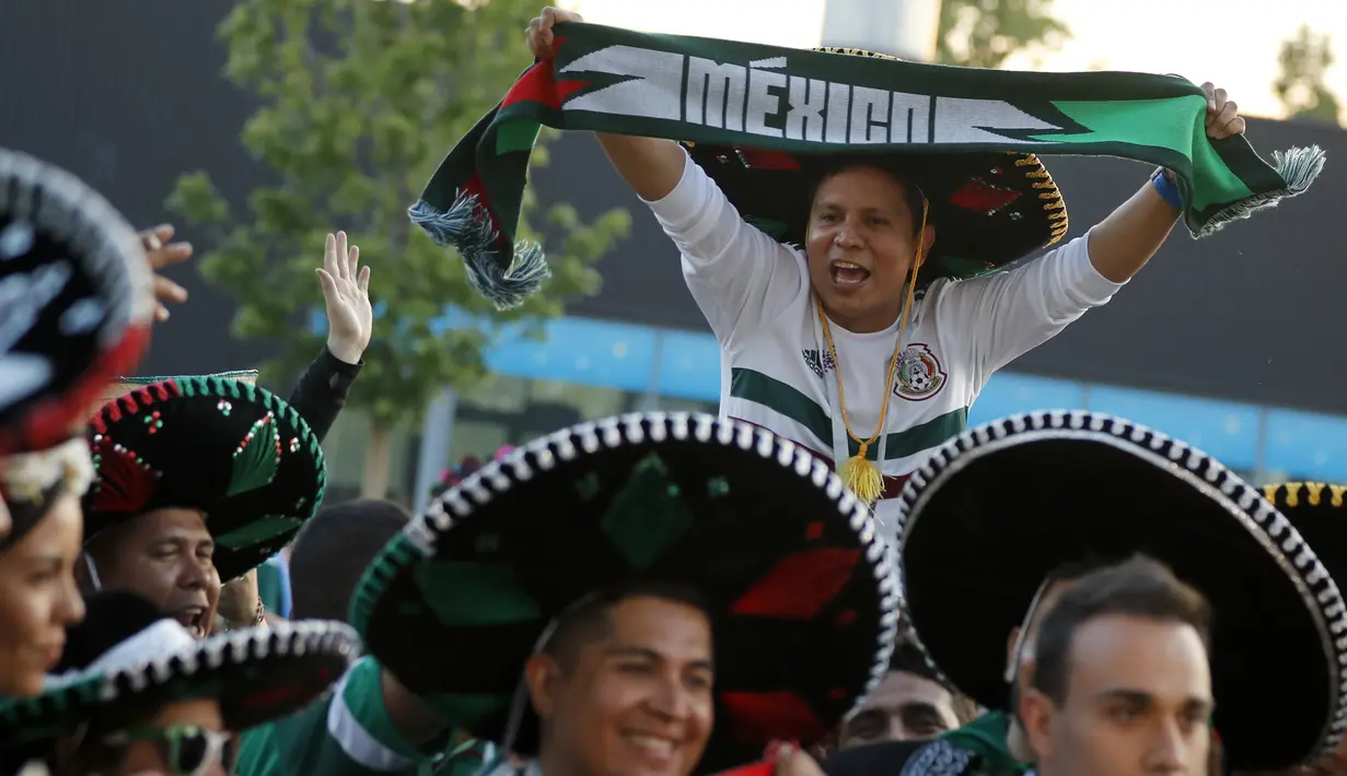 Suporter Meksiko menggunakan topi tradisional, Sombrero saat merayakan kemenangan timnya atas Jerman pada Piala Dunia 2018 di Luzhniki Stadium, Moskow, (17/6/2018). Meksiko menan 1-0. (AP/Alexander Zemlianichenko)