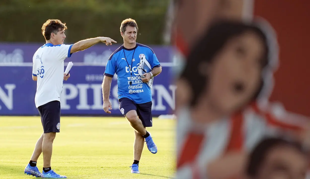Pelatih Parguay Gustavo Barros Schelotto (kiri) dan saudaranya Guillermo berbicara selama sesi latihan di Ypane, Paraguay, Selasa (9/11/2021). Paraguay akan bertanding melawan Chile pada kualifikasi Piala Dunia di Estadio Defensores del Chaco. (AP Photo/Jorge Saenz)
