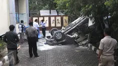 Petugas saat akan menutupi sebuah mobil Toyota Kijang warna merah marun yang jatuh dari lantai 3 Gedung Migas, Jakarta, Selasa (5/4). Mobil itu menabrak dinding pembatas di lantai 3 dan kemudian jatuh terbalik. (Liputan6.com/Helmi Affandi)