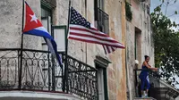 Bendera Kuba dan AS terlihat di balkon salah tempat warga di Havana, Kuba (20/3). Kunjungan Obama untuk membuka babak baru hubungan antar dua negara tersebut. REUTERS/Alexandre Meneghini)