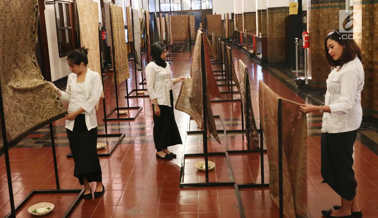 Sejumlah pengunjung melihat kain batik di Musium Bank Mandiri, Jakarta, Rabu (25/10). Pameran batik 100 kain negeri tersebut merupakan karya desainer Oscar Lawalata. (Liputan6.com/Angga Yuniar)