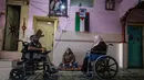 Nihad Jarboa (37) dan istrinya Zeinab (35), warga Palestina yang hidup dengan cacat fisik sejak masa kanak-kanak berada di rumah mereka di kamp pengungsi Rafah di Jalur Gaza selatan, pada 19 Juli 2020.  Suami dan istri tersebut tinggal dengan dua anaknya di rumah satu kamar. (AFP Photo/Said Khatib)