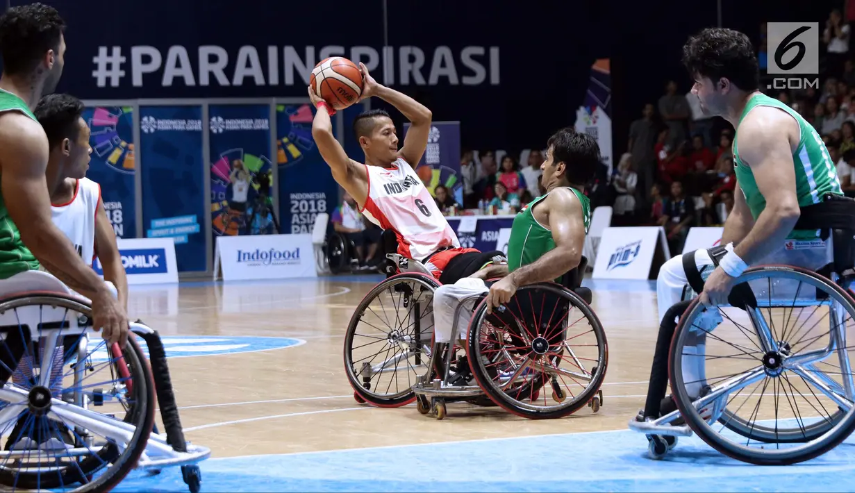 Pebasket Para Indonesia, Danu Kuswantoro (tengah) mencoba melewati kawalan pemain Irak pada kompetisi basket Asian Para Games 2018 di Hall Basket, Kompleks GBK, Jakarta, Kamis (11/10). Indonesia kalah telak 27-97. (Liputan6.com/Helmi Fithriansyah)