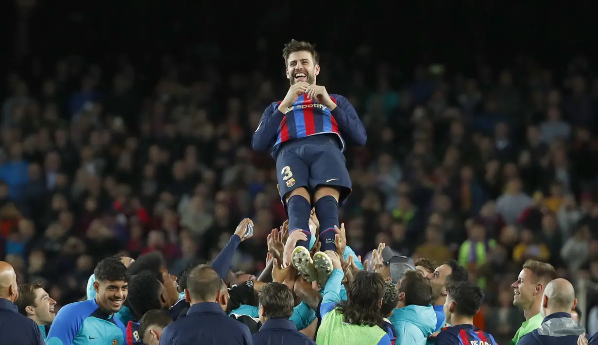 Bek Barcelona, Gerard Pique dilempar ke udara oleh rekan setimnya setalah pertandingan melawan Almeria di stadion Camp Nou di Barcelona, Spanyol, Minggu (6/11/2022).  Gerard Pique resmi meninggalkan Barcelona sekaligus pensiun sebagai pemain sepak bola. (AP Photo/Joan Monfort)