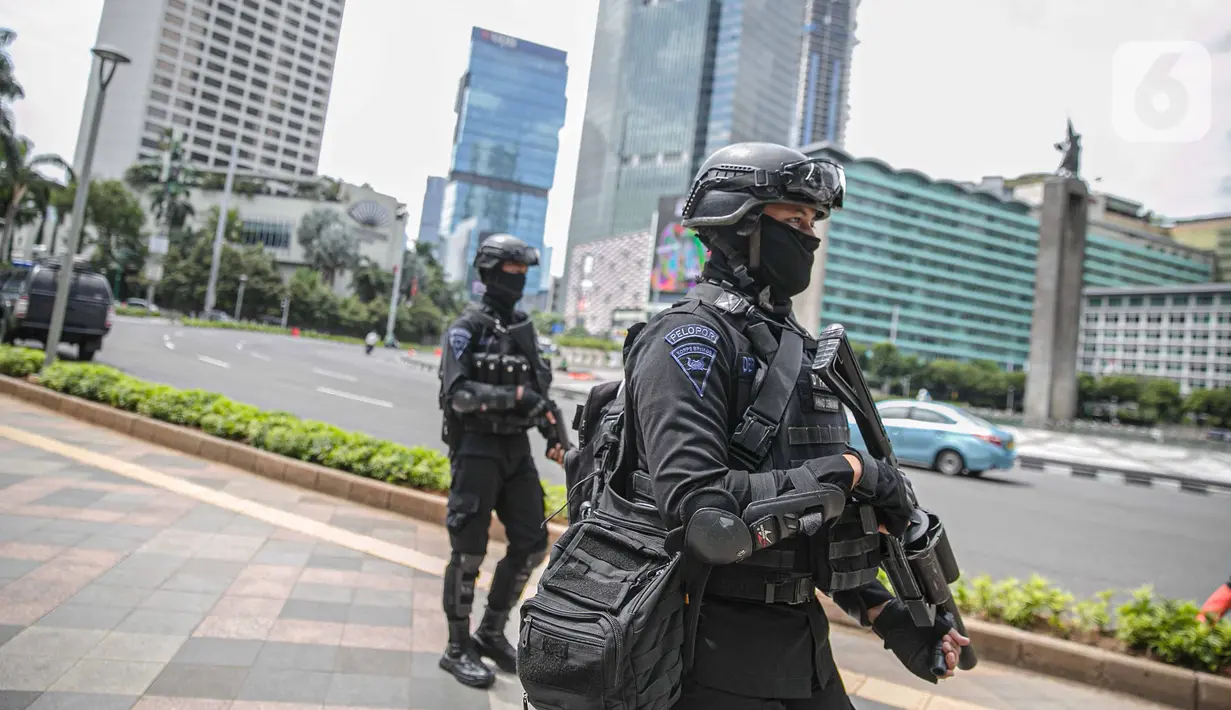 Petugas Brimob dengan senjata lengkap berjaga di kawasan Bundara HI, Jakarta, Kamis (24/12/2020). Pengamanan ini dilakukan guna memberikan pengamanan kepada umat nasrani merayakan malam natal di Jakarta. (Liputan6.com/Faizal Fanani)