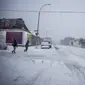 Orang-orang menyeberang jalan selama badai salju di bagian Bushwick di wilayah Brooklyn di New York, Sabtu (29/1/2022). Orang-orang dari New York City hingga Maine terbangun karena salju tebal dan angin kencang saat badai Nor'easter yang kuat melanda. (AP Photo/Brittainy Newman)
