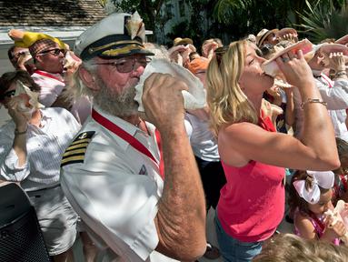 Peserta berkumpul untuk meniup bersama-sama saat lomba meniup tempurung kerang di Key West, Florida, AS, Sabtu (4/3). Lomba meniup tempurung kerang menjadi acara yang ditunggu-tunggu setiap tahun di Florida. (AFP PHOTO/ Rob O'Neal)