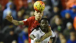 Pemain Liverpool, Martin Skrtel (kiri) berebut bola dengan pemain Swansea City, Bafetimbi Gomis pada lanjutan Liga Premier Inggris antara Liverpool vs Swansea City di Stadion Anfiled, Senin (30/11/2015) dini hari WIB. (AFP Photo/Paul Ellis)