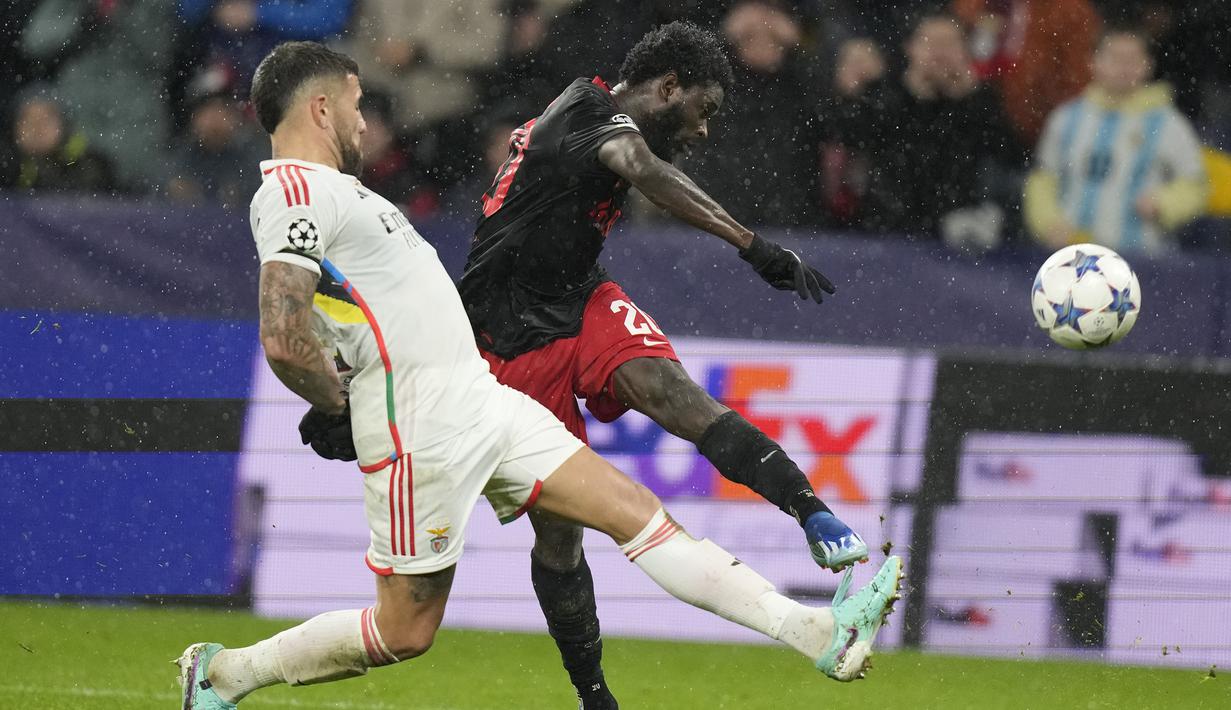 Striker RB Salzburg, Sekou Koita (kanan) melepaskan tendangan yang berusaha diblok bek Benfica, Nicolas Otamendi pada laga matchday keenam Grup D Liga Champions 2023/2024 di Red Bull Arena, Salzburg, Austria, Rabu (13/12/2023) dini hari WIB. (AP Photo/Matthias Schrader)