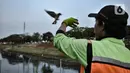 Sulaiman membunyikan peluit saat melatih burung free fly di Jakarta, Minggu (26/7/2020). Jenis burung yang biasa digunakan free fly antara lain kekep, parkit Australia atau falk, kakatua, dan love bird. (merdeka.com/Iqbal Nugroho)