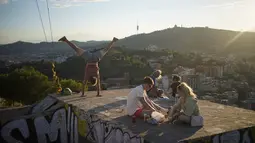 Orang-orang duduk di sudut pandang panorama kota Barcelona, Spanyol, Senin (21/10/2021). Jumlah penduduknya di wilayah pusat kota adalah 1,6 juta jiwa. (AP Photo/Joan Mateu)