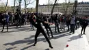 Sejumlah demonstran melempari petugas saat bentrokan terjadi di Place de la Republique, di Paris, Prancis (2/4). Mereka menggelar aksi terkait insiden pria China yang ditembak mati polisi, akhir Maret lalu. (AFP/Benjamin Cremel)
