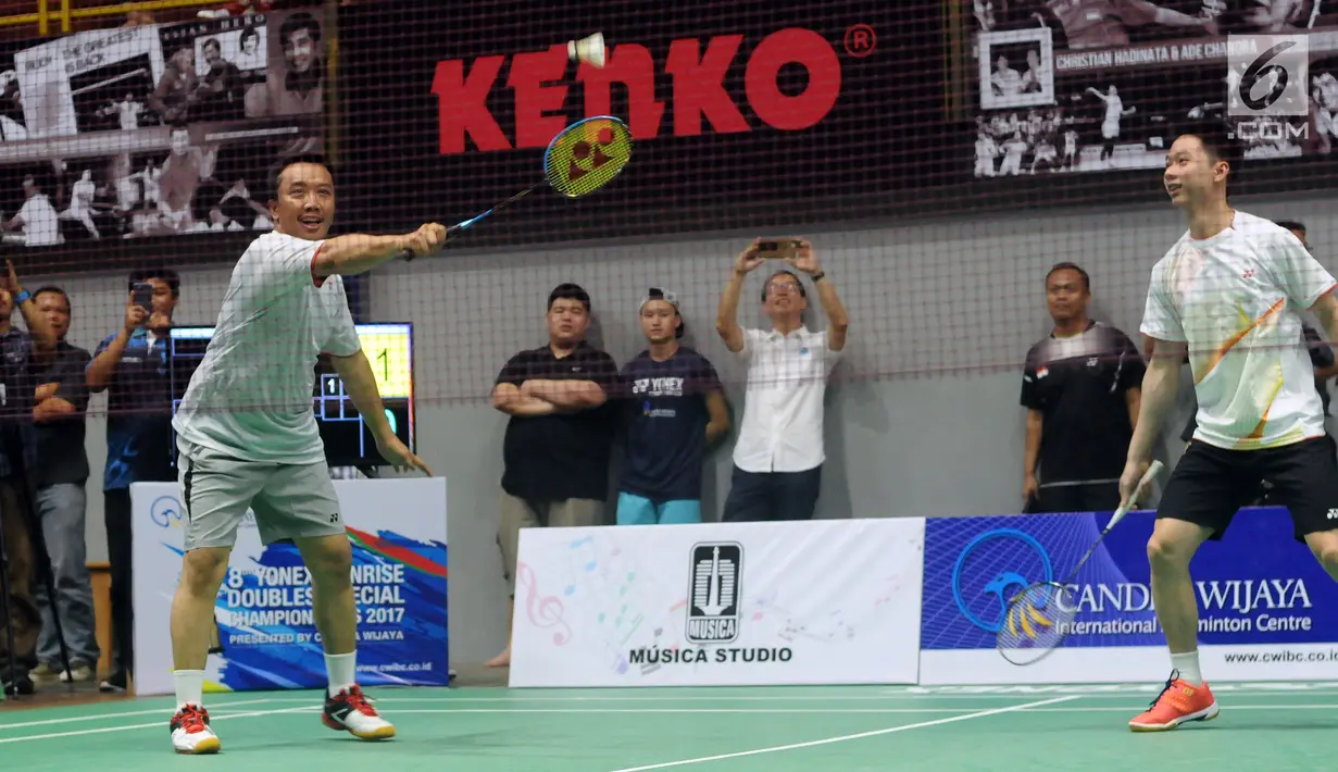 Menpora Imam Nahrawi (kiri) berpasangan dengan Kevin Sanjaya pada laga eksebisi melawan Candra Wijaya/Ricky Subagja di Candra Wijaya Internasional Badminton Centre, Tangerang Banten, Selasa (19/12). (Liputan6.com/Helmi Fithriansyah)