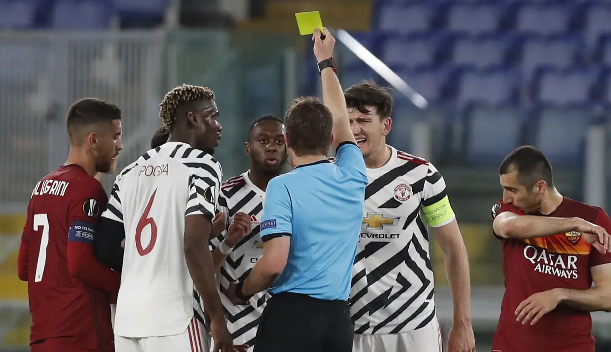 Wasit Felix Brych memberikan kartu kuning kepada bek Manchester United, Aaron Wan Bissaka (tengah) saat melawan AS Roma dalam laga leg kedua semifinal Liga Europa 2020/2021 di Olimpico Stadium, Roma, Kamis (6/5/2021). Manchester United kalah 2-3 dari AS Roma. (AP/Alessandra Tarantino)