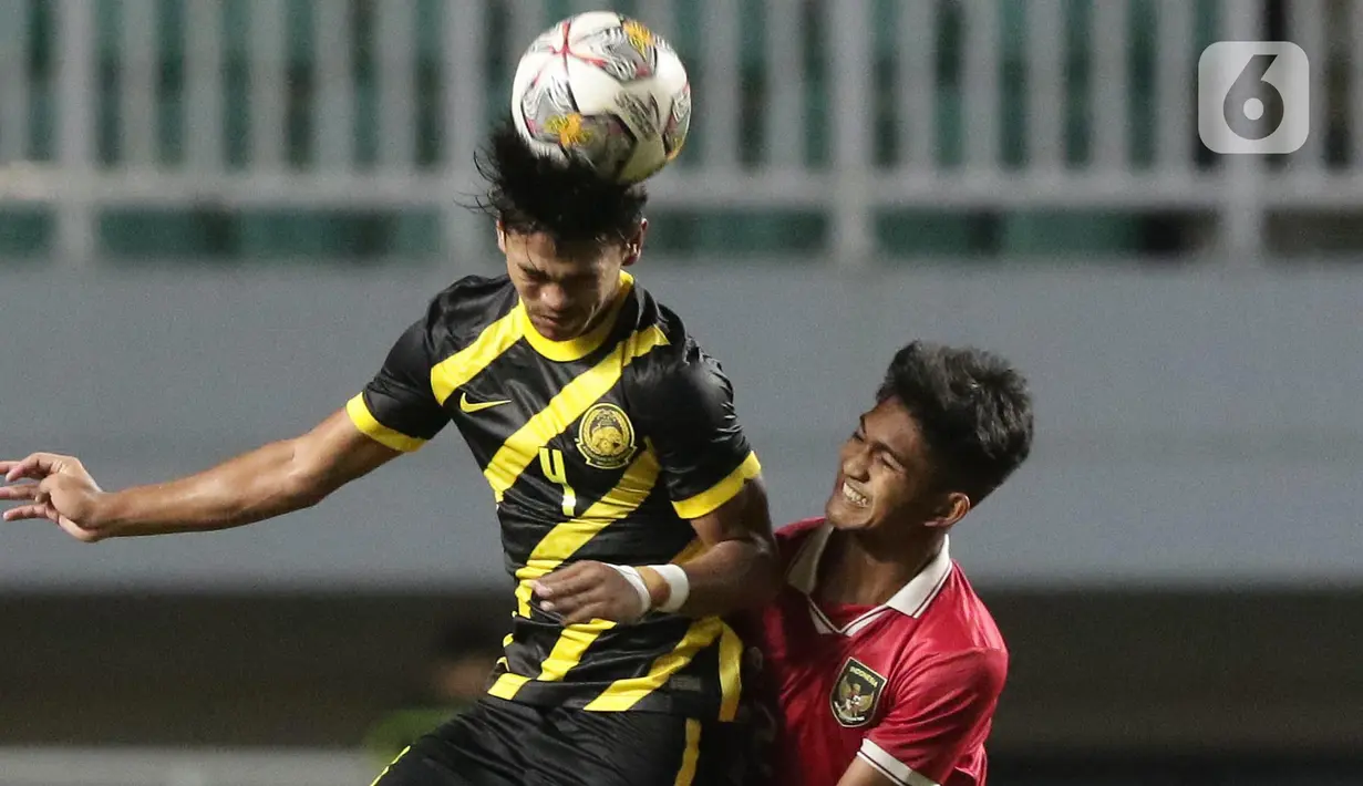 Pemain Timnas U-17 Indonesia, M Narendra Tegar (kanan) berebut bola dengan Adib Ibrahim Adnan (Malaysia U-17) pada laga terakhir Kualifikasi Grup B Piala Asia U-17 2023 di Stadion Pakansari, Kab. Bogor, Jawa Barat, Minggu (9/10/2022). Laga kedua tim berlangsung sengit dan Timnas U-17 Indonesia menelan pil pahit kekalahan dari Malaysia U-17 dengan skor 1-5. (Liputan6.com/Helmi Fithriansyah)