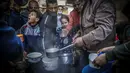 Walid al-Hattab Palestina membagikan sup kepada orang-orang yang membutuhkan selama bulan puasa Ramadhan di tengah pandemi COVID-19 di Kota Gaza (14/4/2021). (AFP/Mohammed Abed)