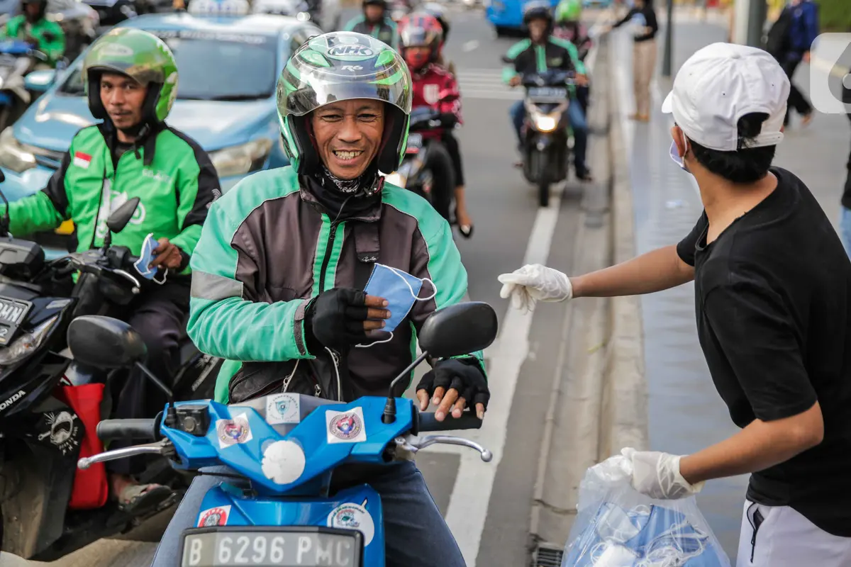 Relawan Bagi-Bagi Masker ke Pengguna Jalan
