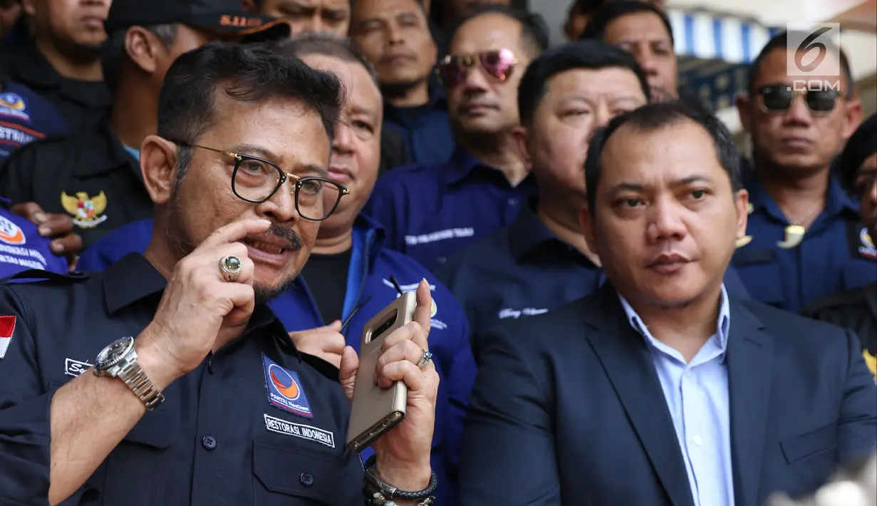 Ketua DPP NasDem Syahrul Yasin Limpo bersama Ketua Bidang Hukum, Advokasi, dan HAM Partai Nasdem Taufik Basari memberi keterangan usai membuat laporan di Sentra Pelayanan Kepolisian Terpadu Polda Metro Jaya, Senin (17/9). (Liputan6.com/Helmi Fithriansyah)